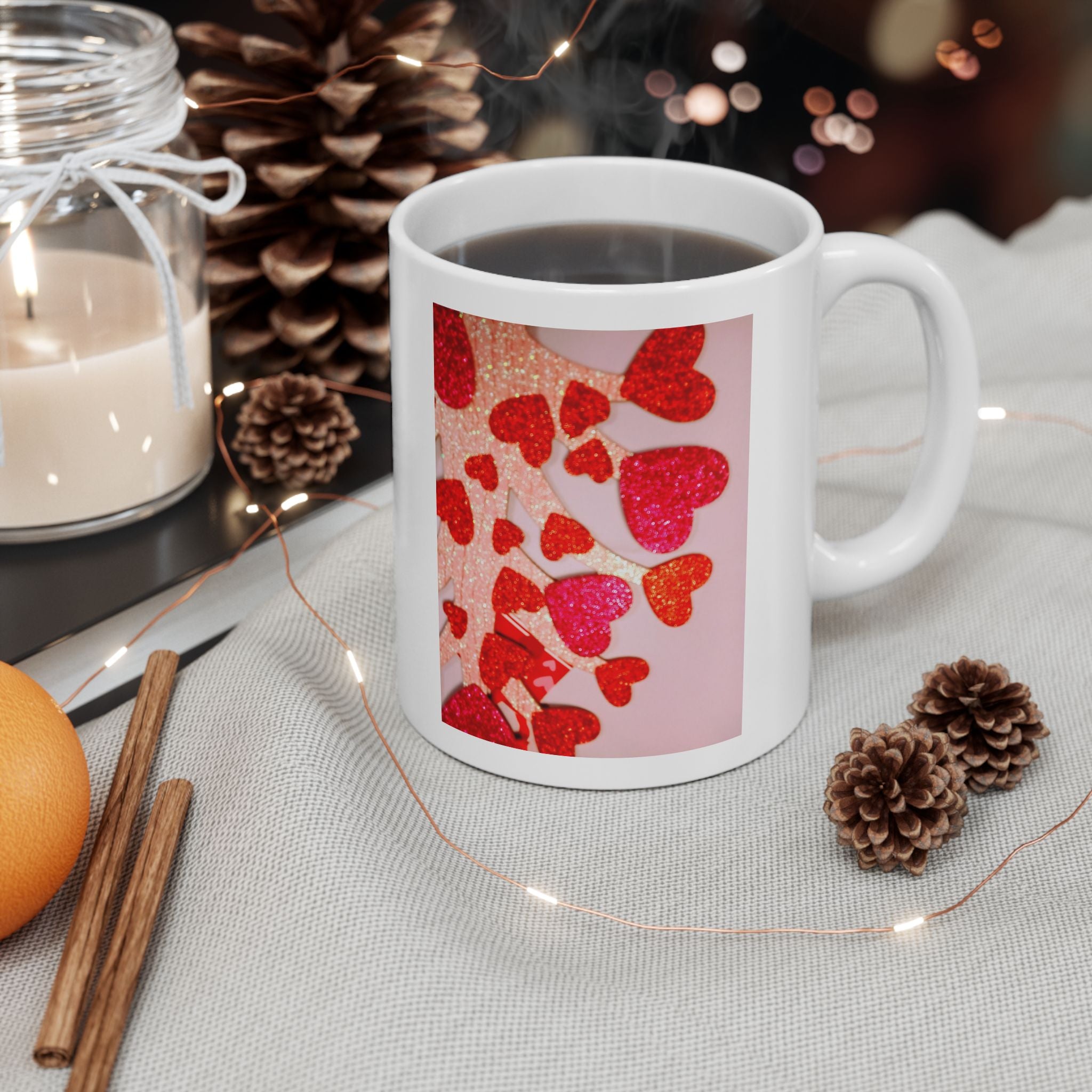 White mug with red heart design on a table with decorative items